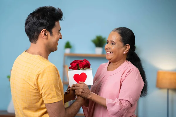 快乐的印度儿子祝福母亲节 在家里送给年老的母亲鲜花卡片 感情和享受的概念 — 图库照片