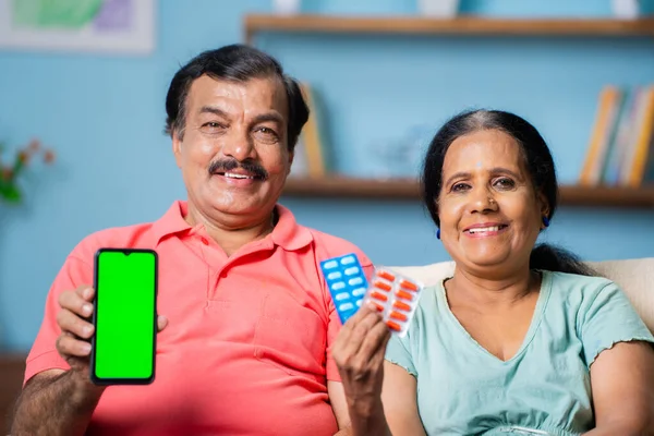 快乐的笑着的印度老夫妇通过在家里看相机来展示绿色屏幕手机 应用程序推广 广告和长期关系的概念 — 图库照片