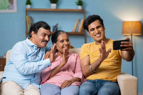 Glücklich Lächelnde Indische Senioren Mit Erwachsenem Sohn Der Auf Dem — Stockfoto