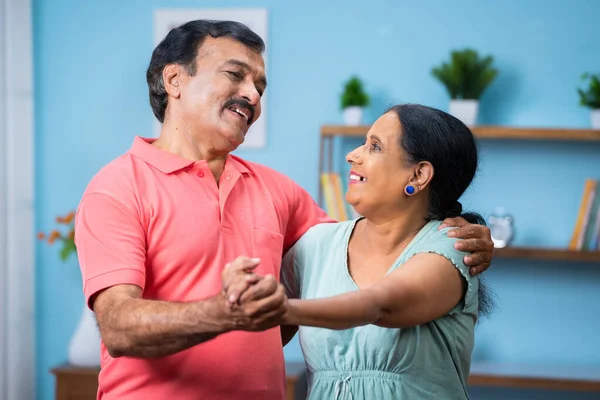 快乐的老夫妇手牵着手在家里跳舞唱歌 积极的退休生活理念 — 图库照片
