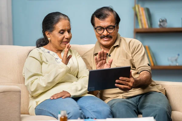 印度老年夫妇在家中用数字平板电脑与医生进行视频通话 在线咨询 医疗和家庭医疗的概念 — 图库照片