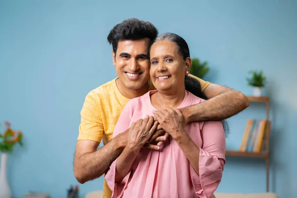 图片说明快乐的印第安成年儿子通过看相机拥抱或拥抱他的大妈 家庭关系和母性的概念 — 图库照片