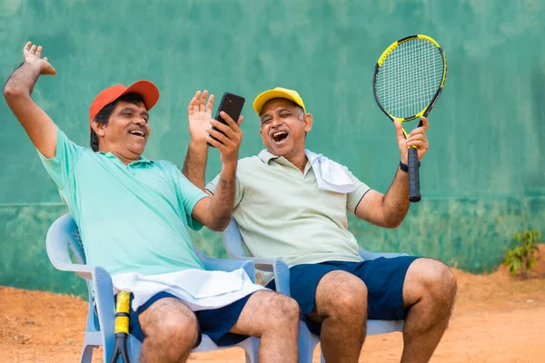 Щасливі Сміються Індійські Старші Друзі Тенісному Корті Дивлячись Мобільний Телефон — стокове фото