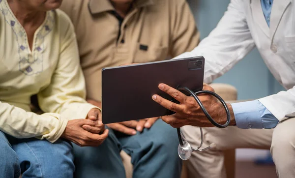 印度医生在家中向老年夫妇展示数码平板电脑医疗报告的特写镜头 治疗和咨询的概念 — 图库照片
