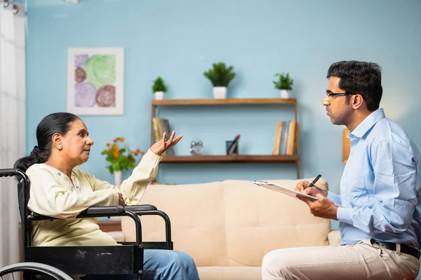 印度家庭心理学家为坐在轮椅上的老年妇女提供咨询 心理创伤的概念 治疗和康复 — 图库照片