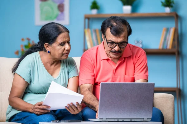 印度老年夫妇通过在家里使用笔记本电脑检查文件或账单进行讨论 财务规划和关系结合的概念 — 图库照片