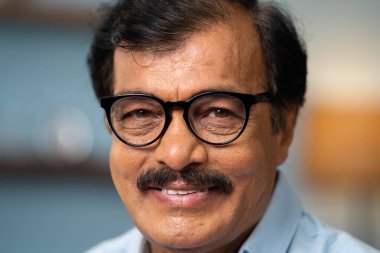 Ekstrem yakın plan mutlu Hintli kıdemli adam kameraya bakarak - başarılı, emeklilik yaşam tarzı ve keyif kavramı.