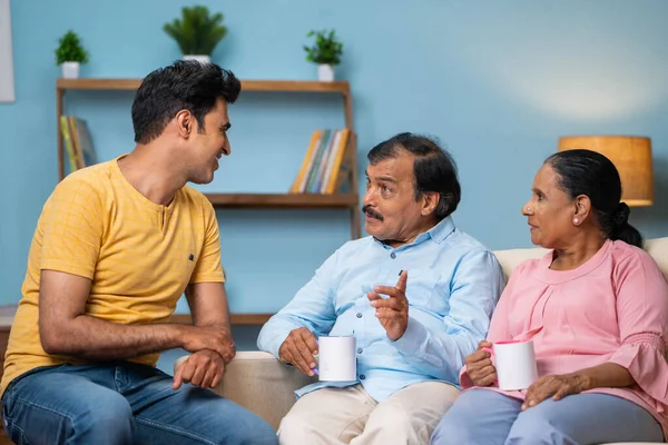 与年长父母一起在家里谈论或讨论的印度快乐的成年儿子 家庭交流 讨论和交流思想的概念 — 图库照片