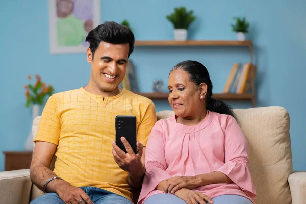 Joyeux Fils Indien Adulte Souriant Montrant Téléphone Portable Mère Aînée — Photo