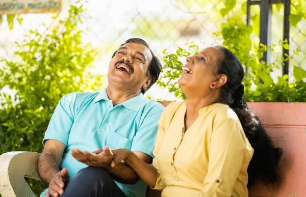 坐在公园里谈笑风生的印第安老夫妇 对话和退休生活方式的概念 — 图库照片