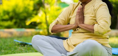 Hintli son sınıf öğrencisinin namaste ya da Mudra yogası yaparken ya da parkta meditasyon yaparken yakın çekim - sağlık konsepti, aktif sağlıklı yaşam tarzı ve Zen.