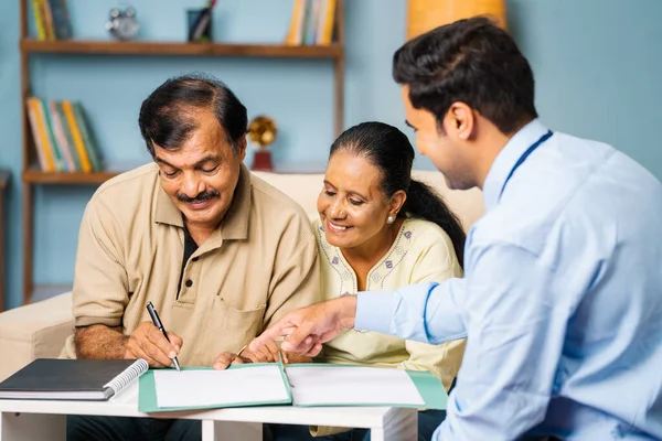 印度银行家在与妻子在家时与年长男子签署文件 善于理财顾问 房地产经纪人和满意的客户 — 图库照片