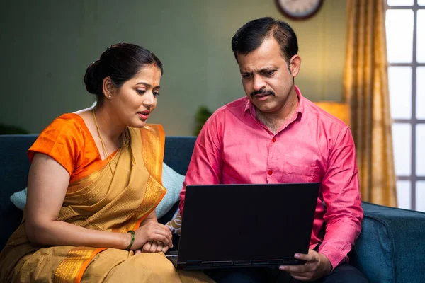Індійська Пара Середнього Віку Обговорює Спостерігаючи Ноутбуком Вдома Дивані Концепцію — стокове фото