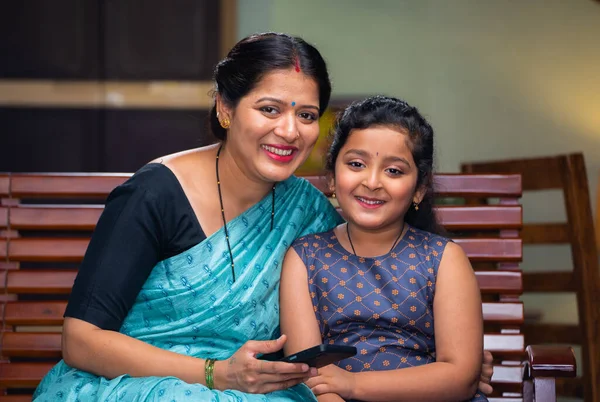 Щаслива Усміхнена Індійська Мати Дочкою Дивиться Камеру Сидячи Дивані Вдома — стокове фото
