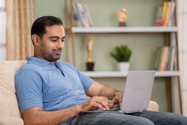 Gelukkig Glimlachende Indiaanse Man Die Laptop Gebruikt Terwijl Hij Thuis — Stockfoto