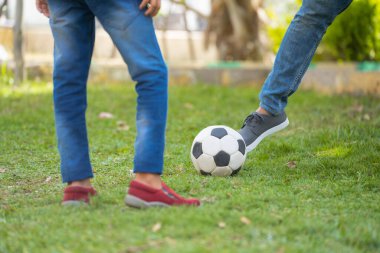 Baba ve oğlunun parkta futbol oynarken yakın çekimi - yaz tatili kavramı, ilişki ve aktif yaşam tarzı