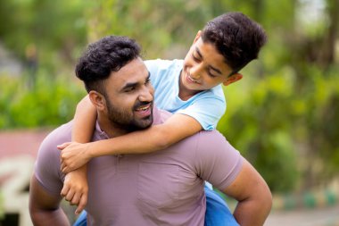 Neşeli, heyecanlı Hintli baba, parkta sırtında taşıyarak oğlunu cesaretlendiriyor. Çocukluk anıları, hafta sonu tatilleri ve tasasız anlar..
