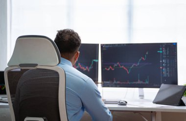 Ofisteki monitörde çizelgeleri analiz eden profesyonel tüccarın omuz fotoğrafı - Teknik Analiz, Profesyonel Yatırımcı ve Risk Yönetimi kavramı.
