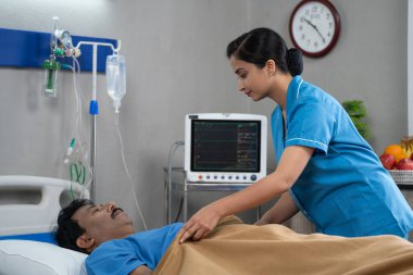 Koğuşta konuşarak hasta hastaya battaniye örten Hintli hemşire - tıbbi bakım, bakım ve tıbbi servis kavramı