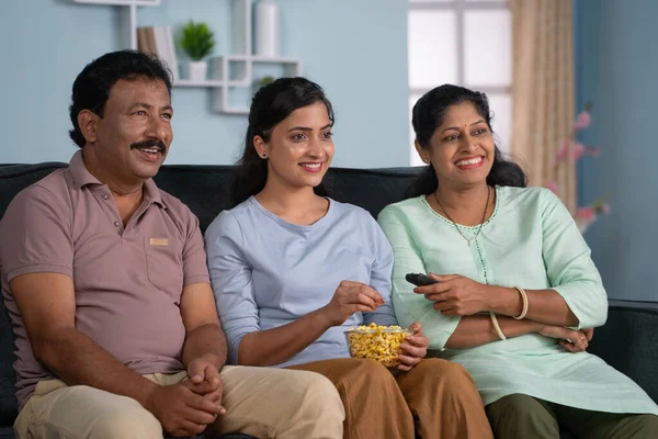 Розслаблений Щасливі Індійські Батьки Дочкою Дивитися Телевізор Або Телевізор Поїдаючи — стокове фото