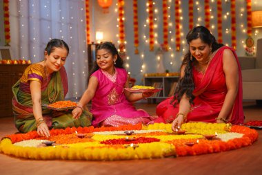 Memleketteki Diwali Festivali kutlamaları için diwali rangoli 'yi hazırlayan neşeli Hintli aile. Geleneksel dekorasyon, ilişki bağı ve tatil buluşması kavramı..