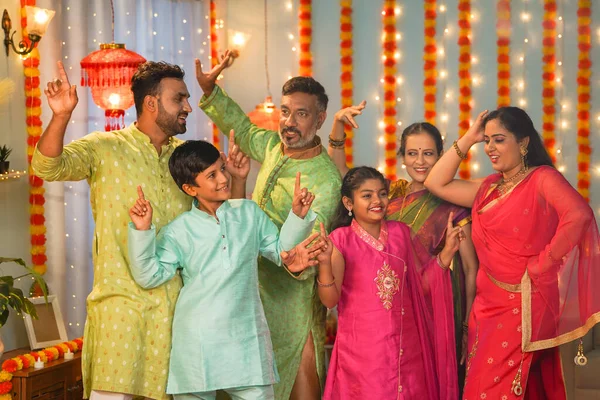Group of family members dancing together during diwali festive celebration gathering at home - concept of entertainment, Holiday reunion and enjoyment.