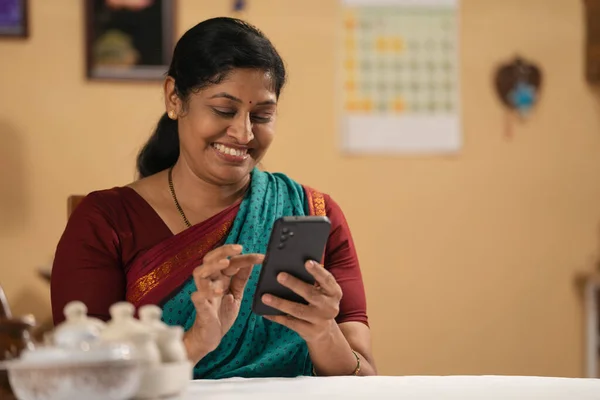 Щаслива Усміхнена Індійська Жінка Середнього Віку Використовує Мобільний Телефон Вдома — стокове фото