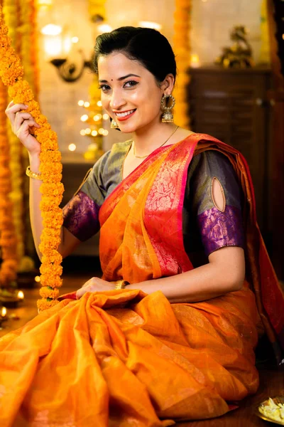 Vertical shot of happy smiling indian girl in traditional ethnic wear looking camera at home during diwali festival - concept of indian culture, festival celebration and traditional.