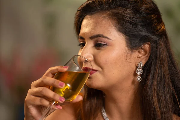 close up shot of Happy smiling Indian woman drinking wine at new year party at restaurant - concept of weekend party celebration, luxury lifestyles and recreation.