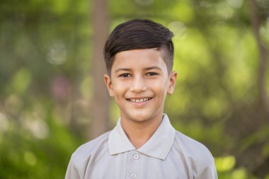 Parkta kameraya bakan mutlu Hintli çocuk - Neşeli İfade, Mutluluk ve Neşeli Çocuk konsepti.