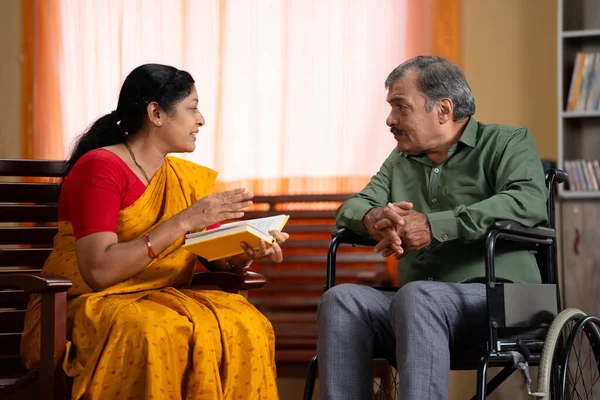 Îngrijirea Soției Senior Indiene Spunând Prin Citirea Romanului Sau Poveștii Imagine de stoc