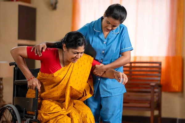 Verpleegster Helpen Vrouw Kleding Uit Rolstoel Tijdens Training Therapie Sessie Rechtenvrije Stockfoto's
