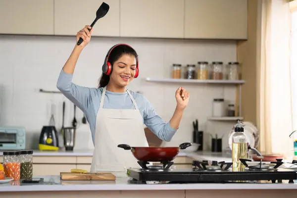 Joyful Dance Індійська Жінка Готує Слухаючи Пісні Бездротових Навушниках Кухні Ліцензійні Стокові Зображення