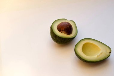 Avokado beyaz arka planda izole edildi. Avokado yarıları. Metin için boş boşluk