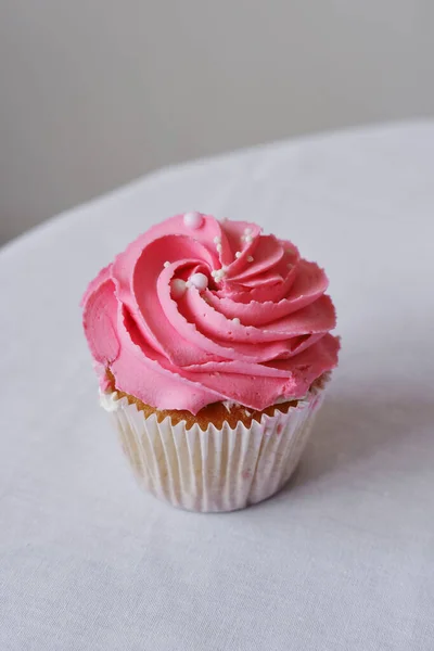 用覆盆子和粉红奶油做成的蛋糕 装饰有可食用的珠子 假日纸杯蛋糕特写 垂直照片 — 图库照片