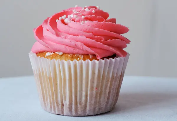 Cupcake Mit Himbeeren Und Rosa Schlagsahne Verziert Mit Essbaren Perlen lizenzfreie Stockfotos