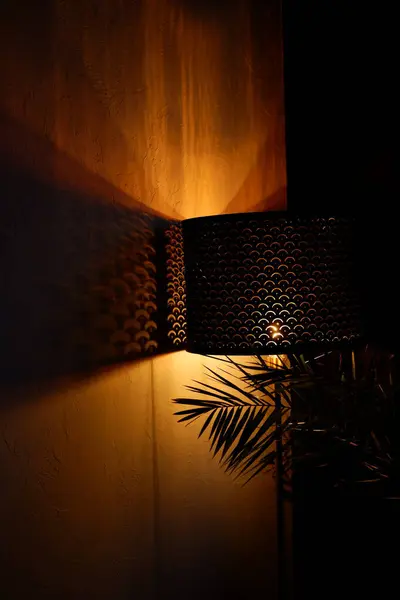 Decorative floor lamp. Home interior with floor lamp and indoor fern plant. orange light from lamp