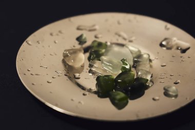 sea multi-colored small stones close-up on a silver saucer. subject photography