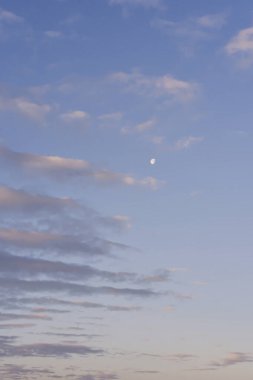 Şafakta sabah ayı. Pembe bulutlar ve ay ile şafak vakti mavi gökyüzü