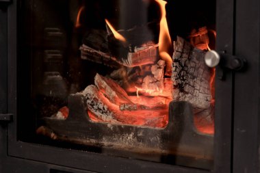 Evde şömineye yakın çekim. İç şömine. Küçük bir şöminenin içinde alevler. arkaplan resmi