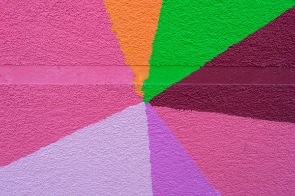 Grainy wall divided into colors forming triangles