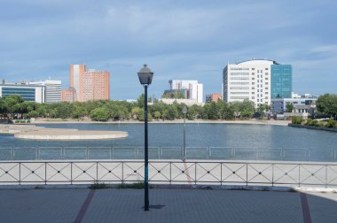 Madrid 'deki 12 de Octubre hastanesinin binalarıyla Pradolongo park havuzu manzarası. İspanya