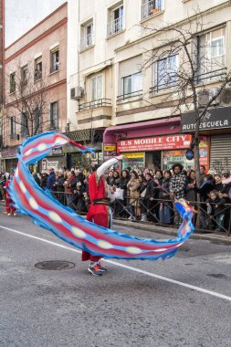 Geçit töreninde mavi kurdele sallayan Çinli bir kadın. Fotoğraf 11 Şubat 'ta Madrid' deki Usera mahallesindeki Çin Yeni Yıl Geçidi sırasında çekildi. İspanya