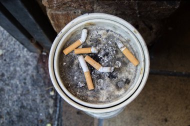 Sigaraların geri kalanı da kül tablasında, yukarıdan görünen bir sokakta.