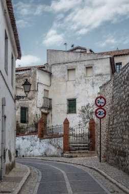 Madrid 'in Chinchon şehrinde metal kapıları ve trafik işaretleri olan virajlı bir cadde. İspanya