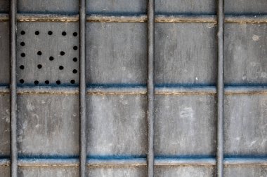 Metal çubuklu metal plaka kare oluşturuyor ve sol üst köşede daireler var.