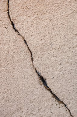 Sağdan sola doğru uzanan dikey bir çatlakla dokulu duvar.