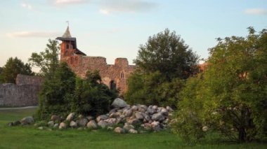 Dobele Kalesi 'nin merkez binası Letonya, Avrupa' da bir kulesi olan kayalardan inşa edildi. Bu ortaçağ mimari abidesinin manzarası zoom-in-motion sahnesinde..