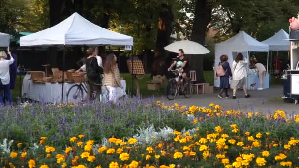 ラトビアのリガ 2021年9月 人々は町の公園で屋外の夏の市場を訪れます トレードテント付きのポップアップマーケット ホームプロデューサー事業 — ストック動画