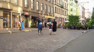 Riga, Letonya - 18 Ağustos 2020. Başkentte insanların olduğu bir yaya sokağı. Vatandaşlar ve turistler sokak kafeleri olan bir şehir merkezinde yürüyorlar. Yaz mevsimi boyunca güneşli bir hafta sonu.